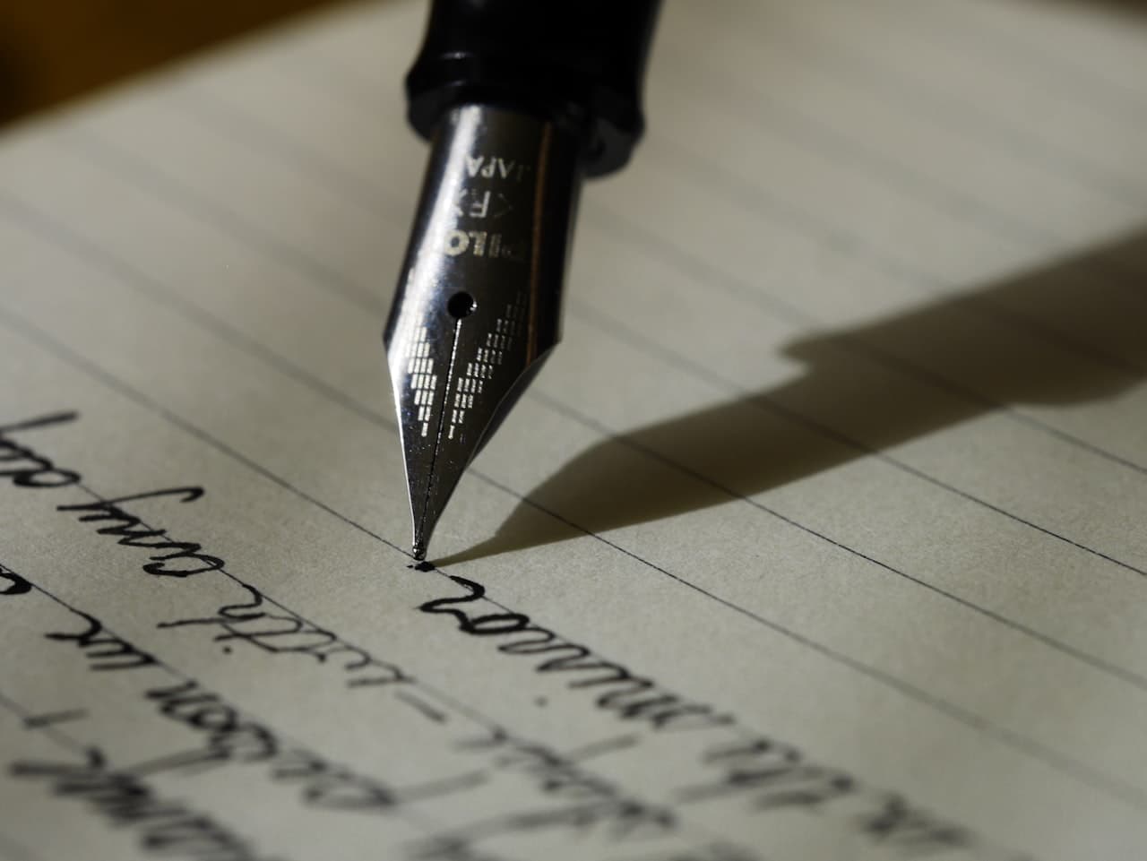An open notebook with a hand-written letter in ink, on a wooden surface — the kind of memory Confinity is built to hold.