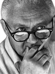A black-and-white portrait of American graphic designer Paul Rand, known for his iconic corporate logo designs, including IBM and ABC. He is depicted wearing glasses, with a thoughtful expression, holding a pencil near his chin. The close-up image emphasizes Rand's intellectual and creative approach, reflecting his influence on modern graphic design and visual communication.