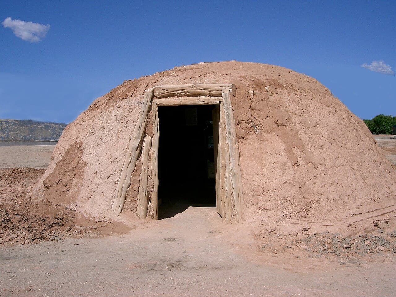 A Navajo hogan, a round timber and earth dwelling with its door facing east