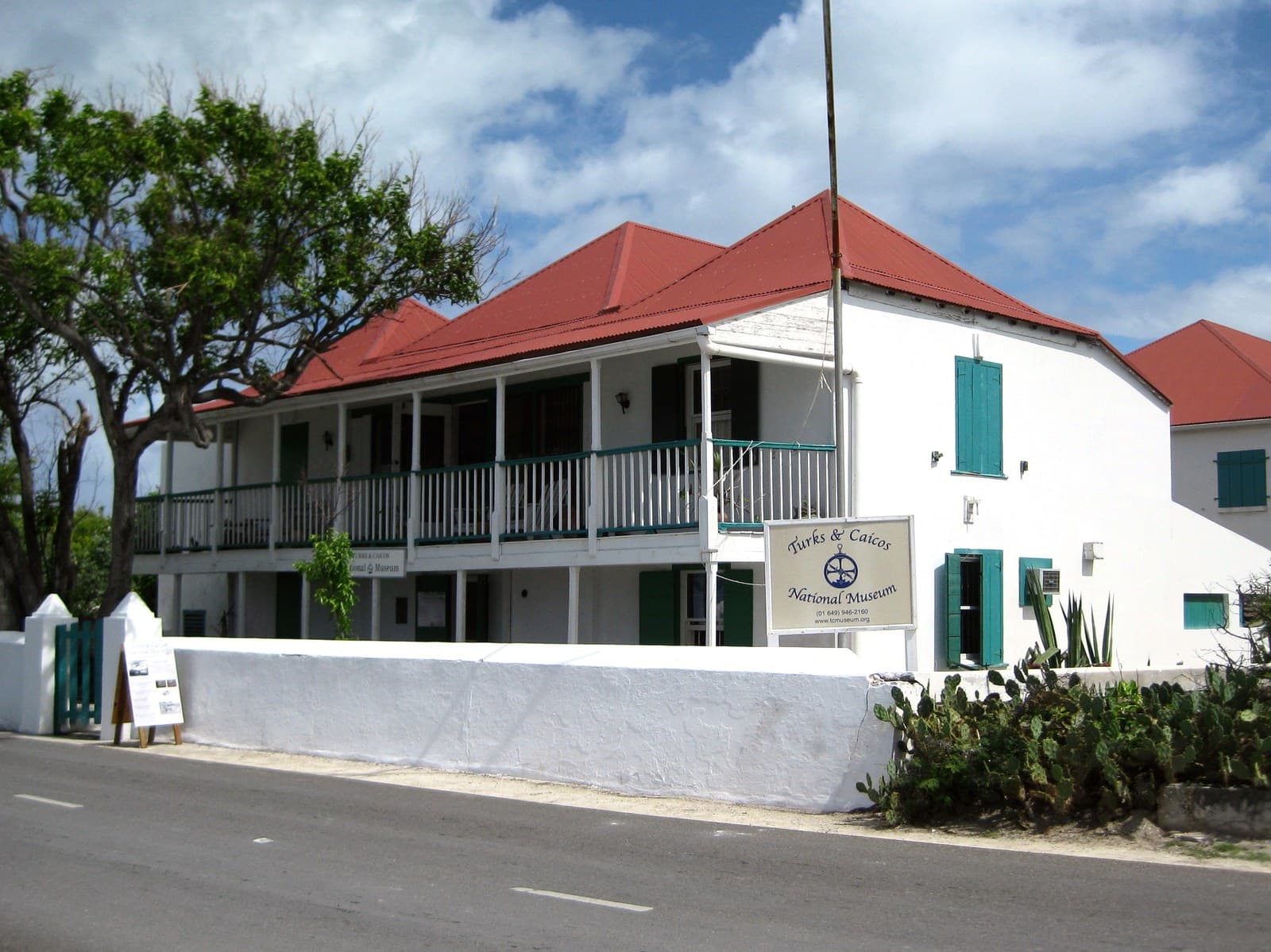 Guinep House on Front Street in Cockburn Town, Grand Turk, a white two-storey building with a red roof and a shaded verandah, now the Turks and Caicos National Museum